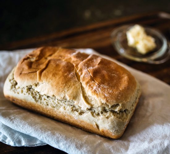 photo of bread with butter in the background